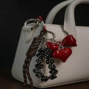 خرید آنلاین اویز کیف و کلید زنانه مدل پاپیون و تاس از جنس پلاستیک فشرده و چرم