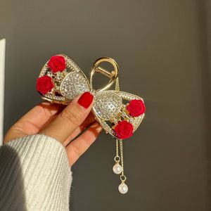 خرید اینترنتی قیمت کلیپس مجلسی فلزی گل قرمز آویزدار