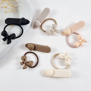 فروش اینترنتی ست کش مو و گیره انبری مدل شمعی مات طرح قلب و پاپیون (بسته 2 عددی)